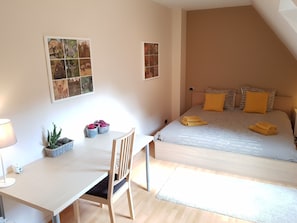 Ein Schlafzimmer mit Bett, Nachttischen, Schreibtisch und Stuhl.