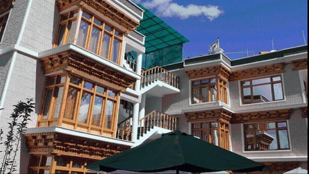 A multi-story building with traditional architectural features, including wooden balconies and large windows. - Hotel Om Ladakh (Leh)