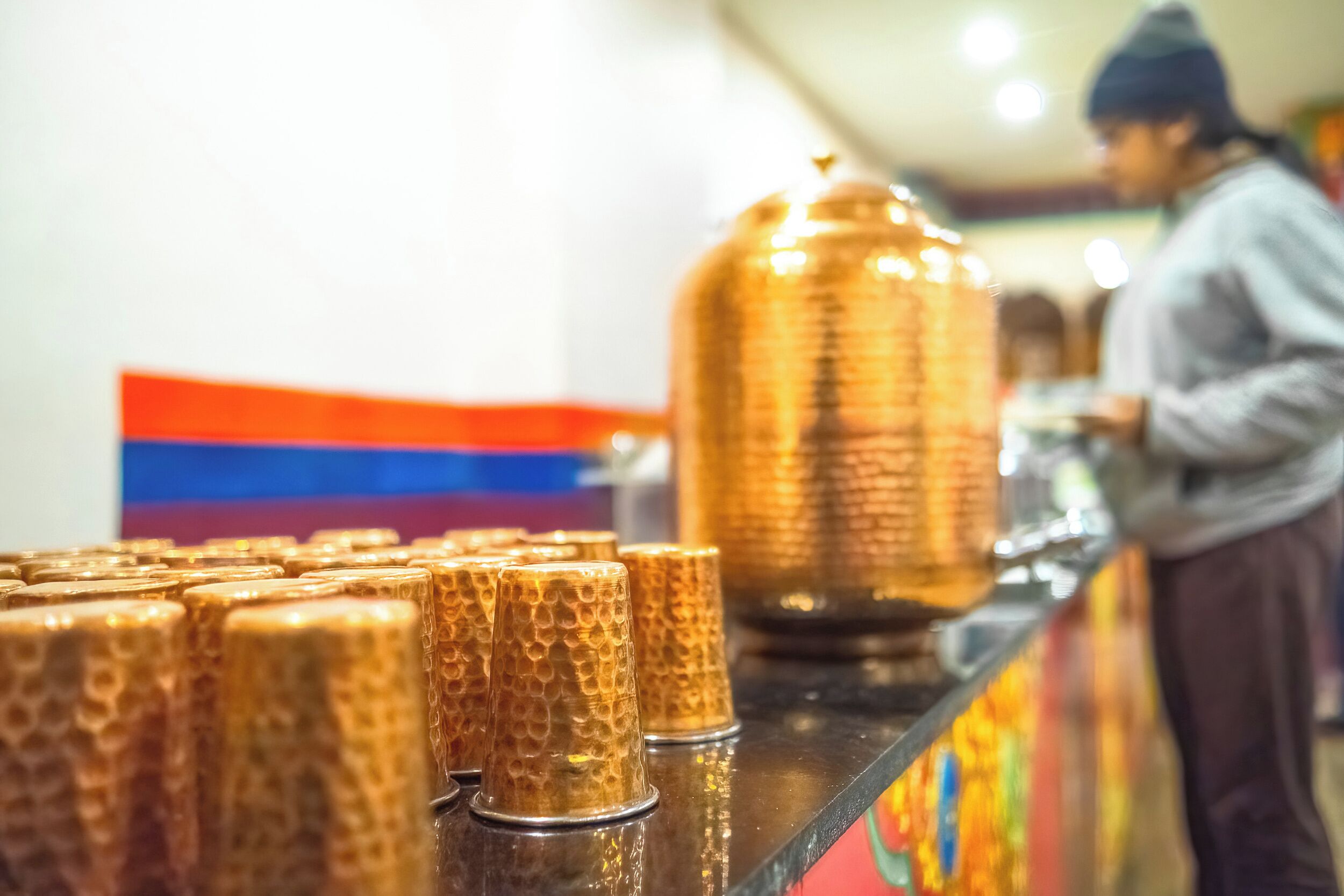 Zona de bar con mostrador y una olla grande de cobre.