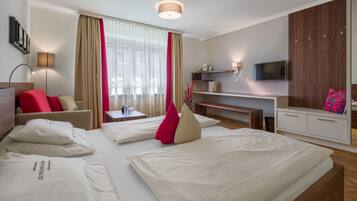A hotel room with two beds, a desk, a TV, and a wardrobe.