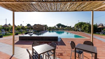 Una piscina al aire libre de temporada, sombrillas