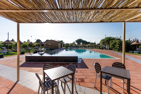 Una piscina al aire libre de temporada, sombrillas