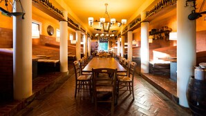 A long dining table with chairs, surrounded by brick walls and white pillars. - Trere Agriturismo (Faenza)
