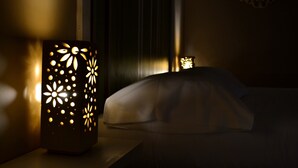 Un lit avec une tête de lit blanche et une applique murale décorative ornée d’un motif floral.