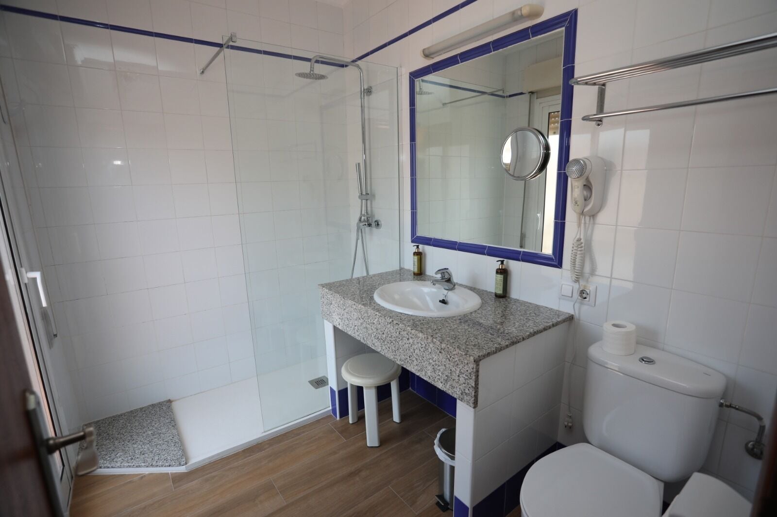 Une salle de bain équipée d’une douche, d’un lavabo, de toilettes et d’un miroir.
