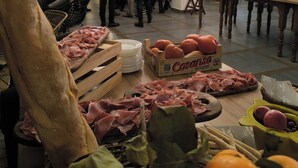 A social event with people mingling, a variety of meats and cheeses on display, and a chandelier hanging from the ceiling. - Hotel Ramis (Ondara)