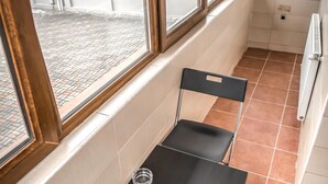 Una habitación pequeña con ventana, una mesa y dos sillas.