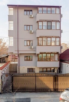 A multi-story residential building with a flat facade, multiple windows, and a gated entrance. - Hotel Elisabeta (Bucharest)