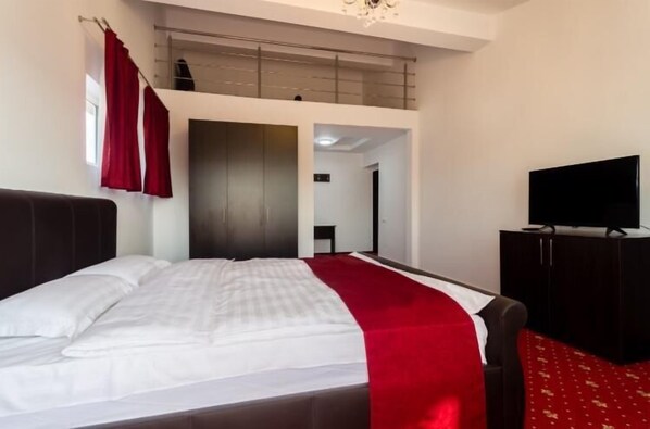 A hotel room with a bed, a TV, a wardrobe, and a balcony. - Hotel Elisabeta (Bucharest)