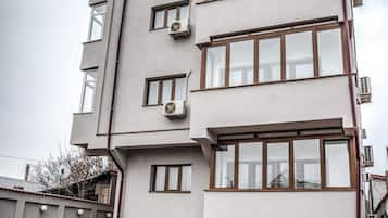 A multi-story building with a flat roof, large windows, and air conditioning units.