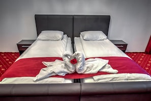 A double bed with a red bedspread and two white pillows. - Hotel Elisabeta (Bucharest)