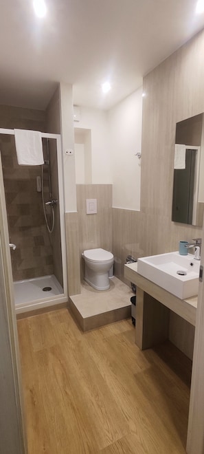 Une salle de bain moderne équipée d’une douche, de toilettes et d’un lavabo.
