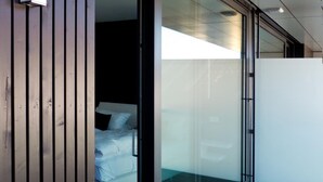 A modern room with a large sliding glass door leading to a balcony. - Porta Vinea (Ruppertsberg)