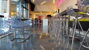 A modern interior with reflective glass chairs and a polished floor, featuring a central counter and large windows. - Porta Vinea (Ruppertsberg)