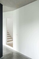 Un interior moderno con una escalera que baja a un nivel inferior.