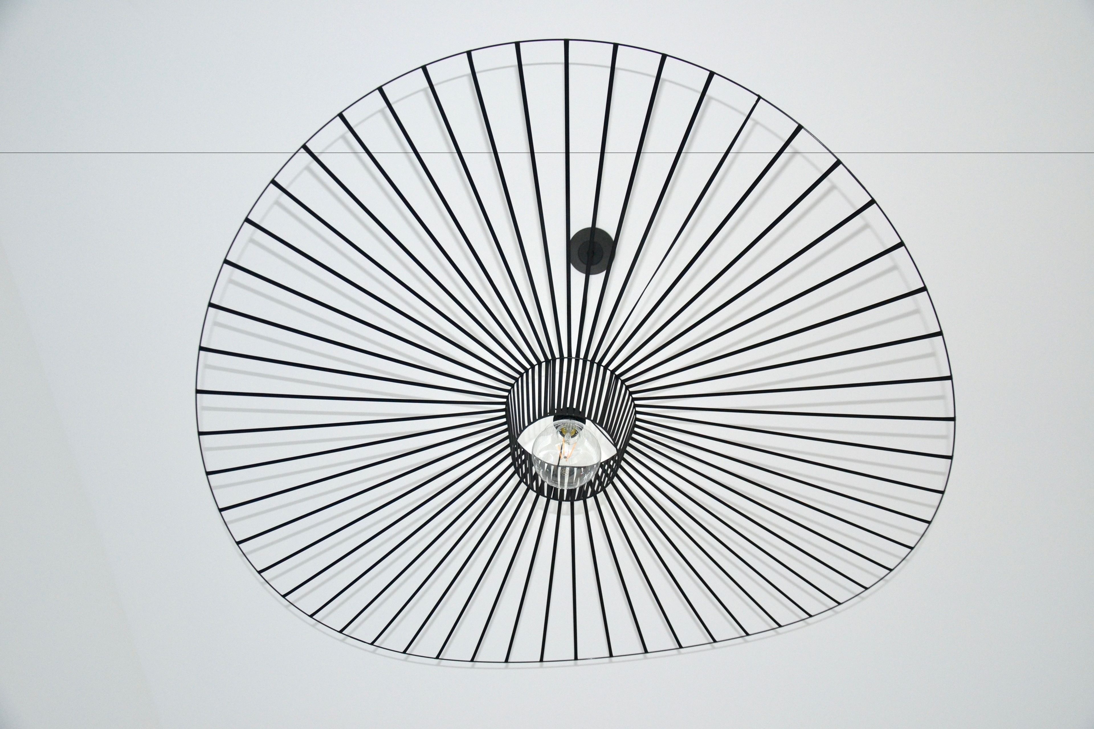 A circular ceiling design with radial lines converging towards a central point.
