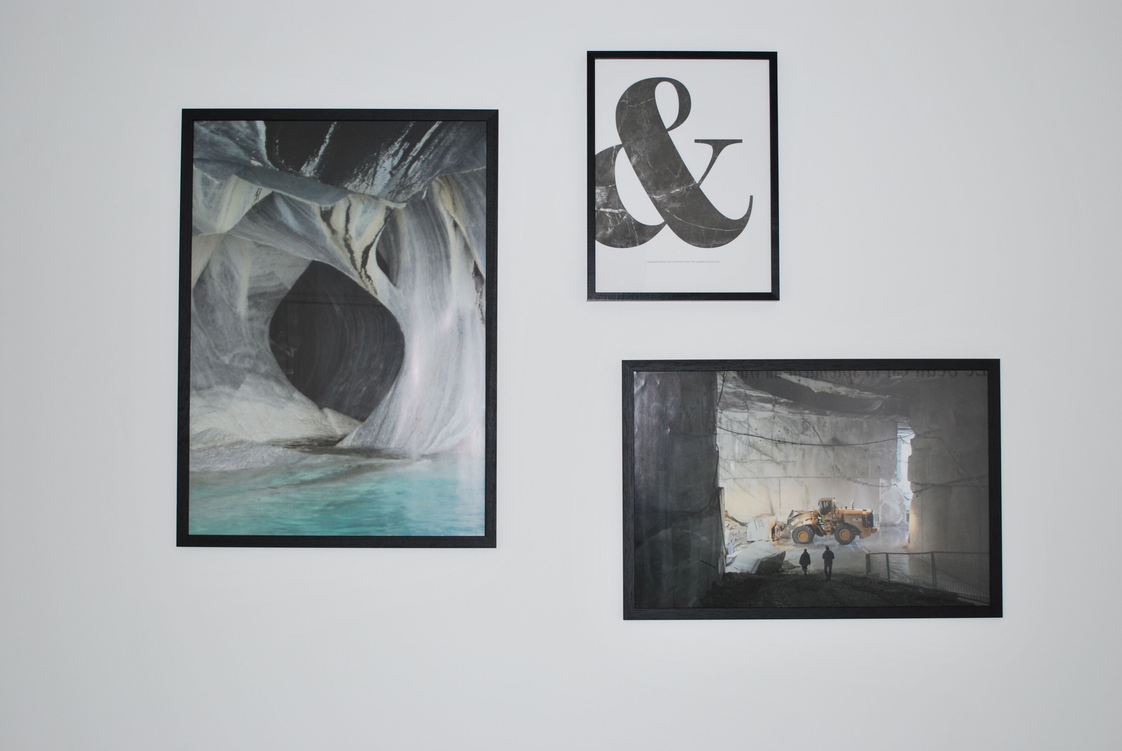 Trois œuvres d’art encadrées sont accrochées au mur.