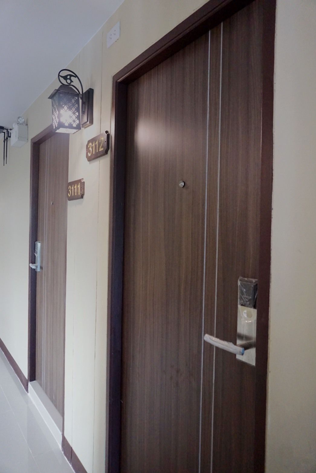 A hallway with two wooden doors, each labeled with a number.
