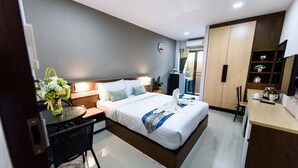 A modern hotel room with a neatly made bed, a small dining table, and a compact kitchenette. - Thana Residence Lam Luk Ka (Lam Luk Ka)