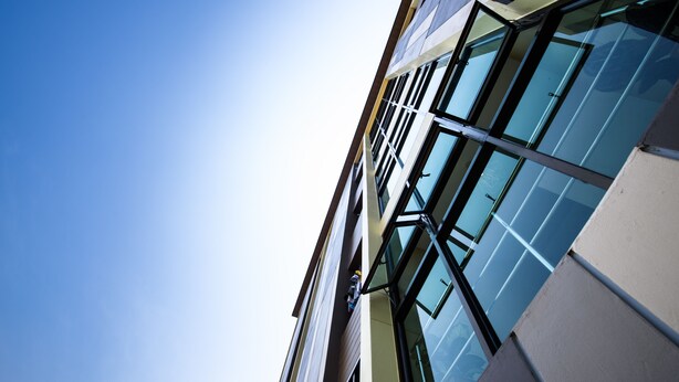 A modern building with large glass windows and a clear blue sky. - Thana Residence Lam Luk Ka (Lam Luk Ka)