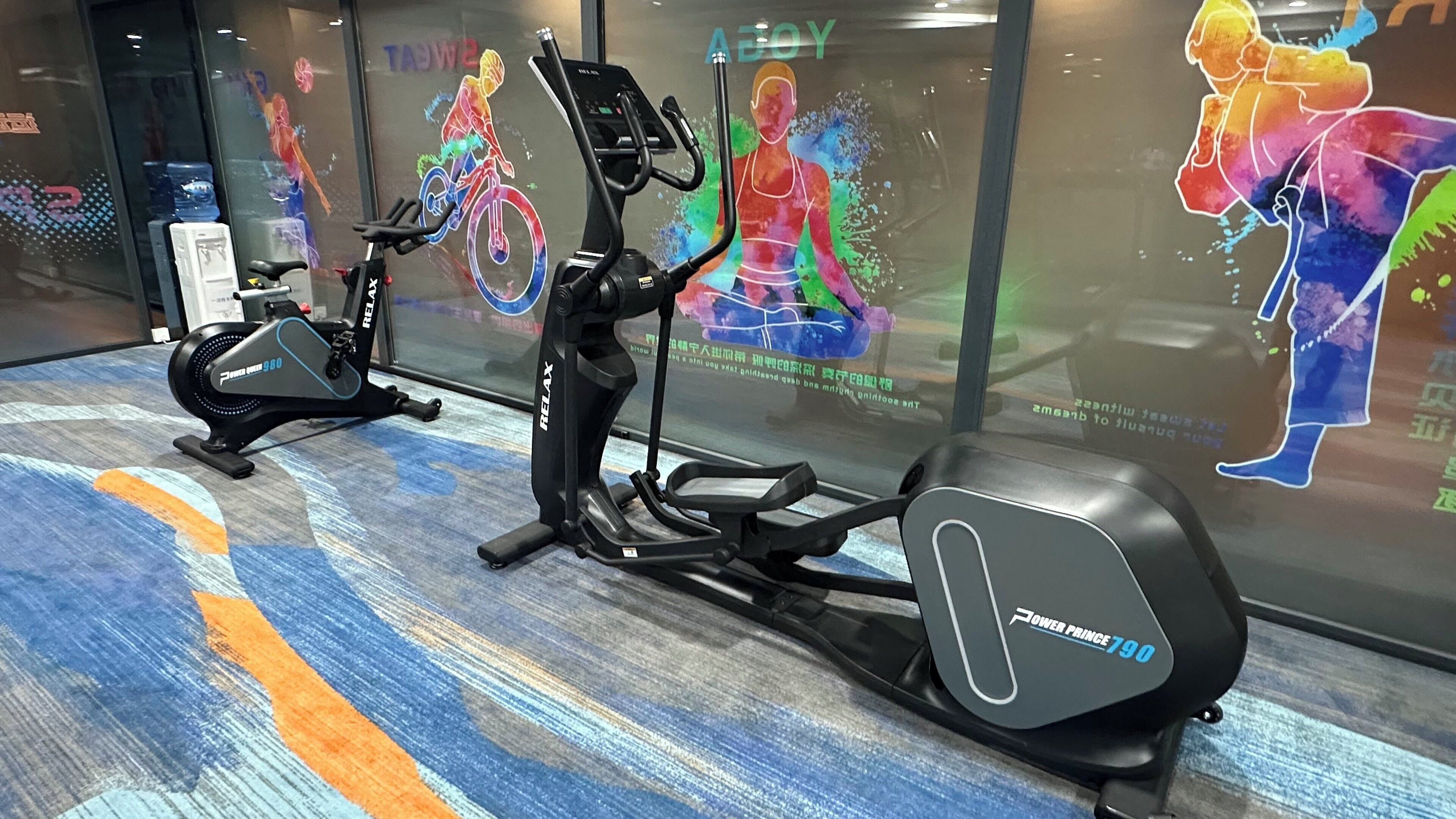A gym with exercise equipment and motivational wall art.