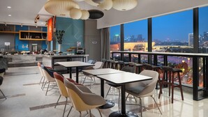 Un restaurant moderne offrant une vue sur le paysage urbain au crépuscule.