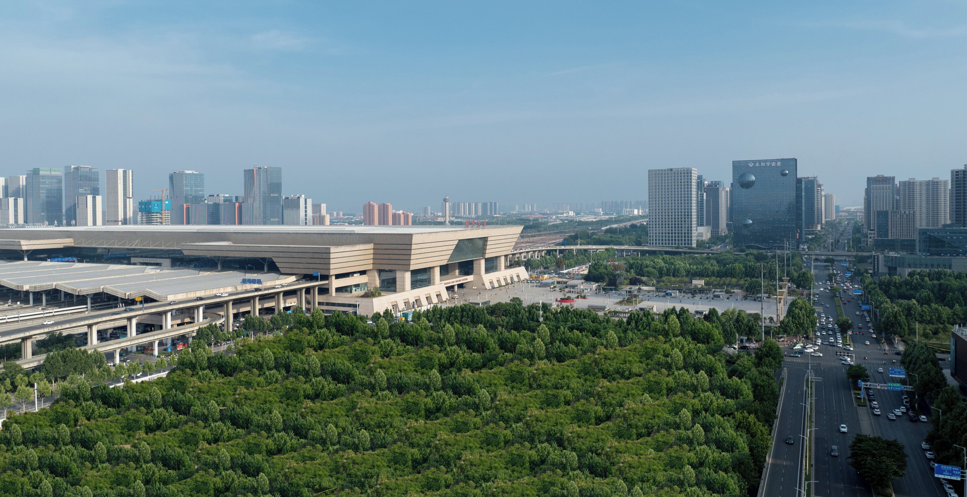 Un paysage urbain moderne avec de hauts immeubles, un grand stade et une autoroute.