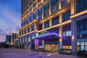 A hotel with a modern facade, a prominent Holiday Inn Express sign, and a well-lit entrance.