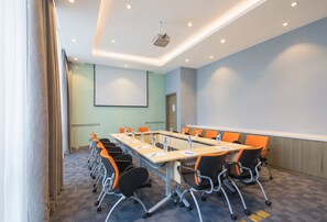 A conference room with a long table, chairs, a projector, and a screen. - Holiday Inn Express Guian Yungu by IHG (Anshun)