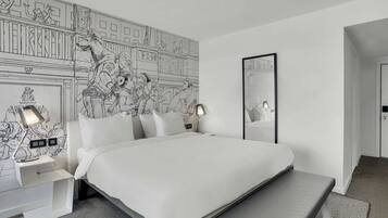 A modern hotel room with a large bed, bedside tables with lamps, a bench, and a mural on the wall.