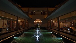 A hotel interior with a central water feature, glass walls, and a reception area. - Wyndham Guilin Pingle (Guilin)