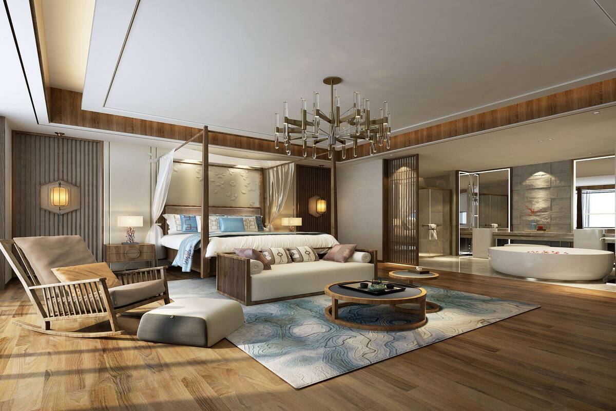 A spacious living area with a large sofa, a rocking chair, a coffee table, and a large window.