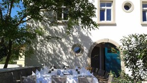 An outdoor dining area with tables set for four, surrounded by chairs. - Rebgut - Die Weinherberge (Lauda)