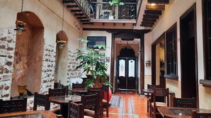A traditional inn with wooden furniture, tiled floors, and a balcony with metal railings. - La Posada Cuencana (Cuenca)