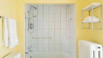 Casa de banho com chuveiro, banheira e porta-toalhas.