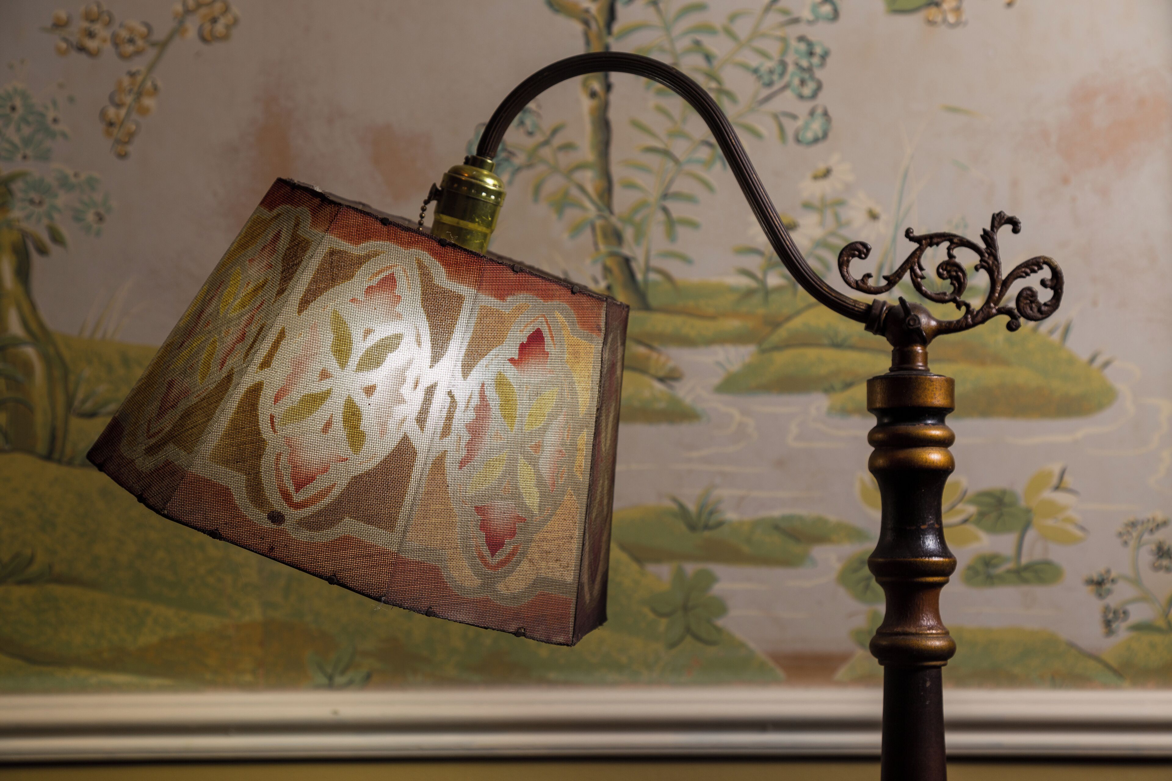 A lamp with a patterned shade and a decorative metal stand.