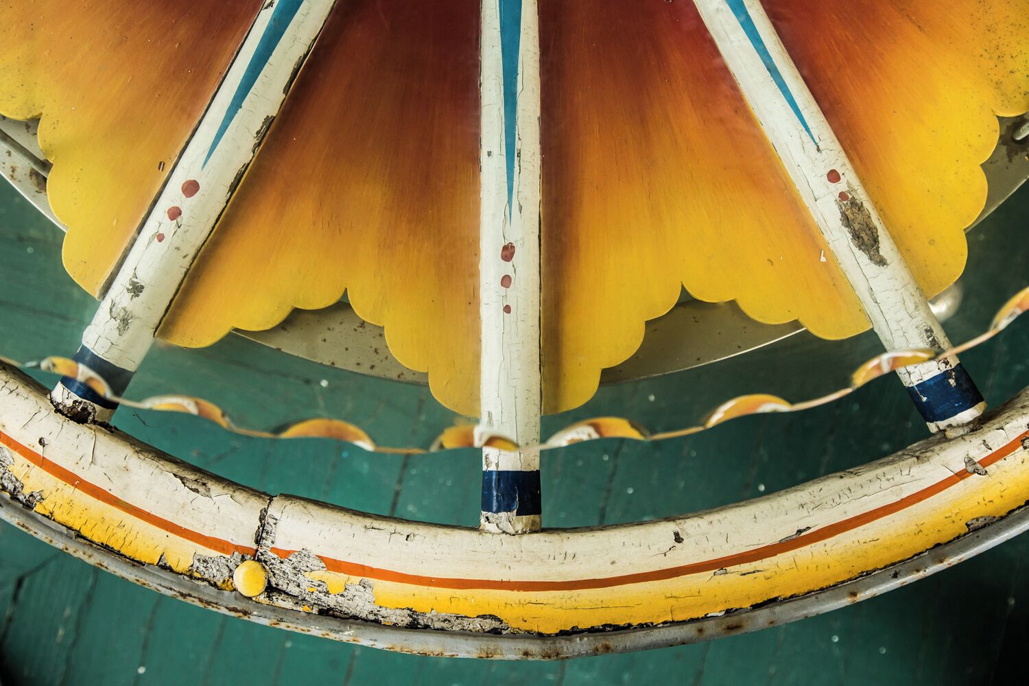 A carousel with peeling paint and rust on metal parts.
