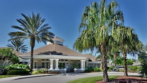 A hotel with a central dome structure, palm trees, and a well-maintained lawn. - Single Level Luxury Villa with Pool and Hot tub close to Disney (Kissimmee)