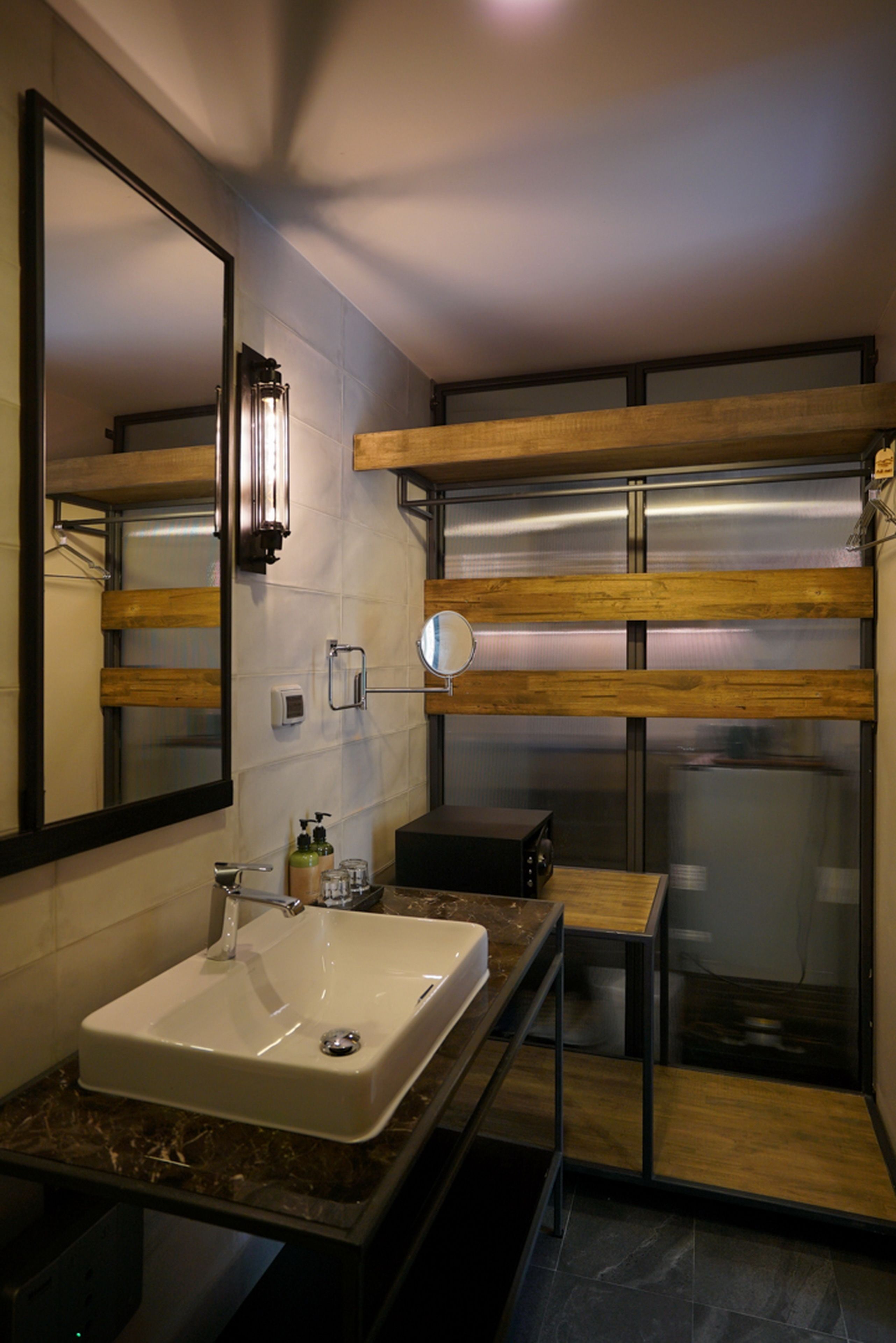 Une salle de bain moderne avec un grand miroir, un lavabo et une cabine de douche.