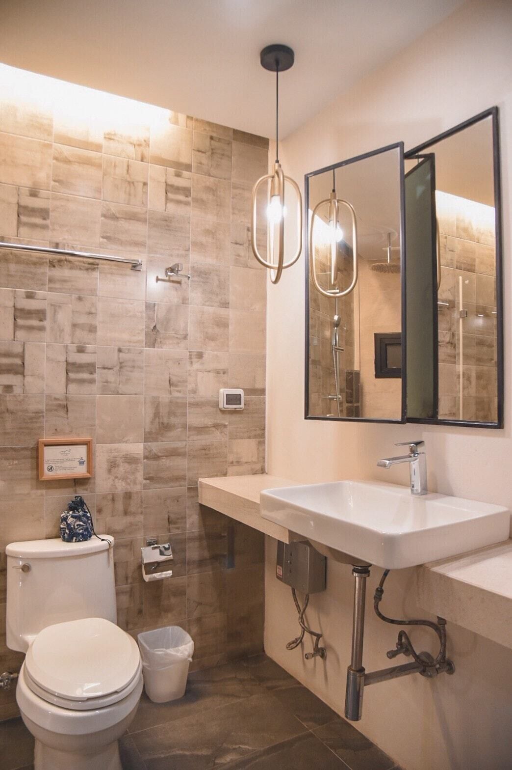 A modern bathroom with a large sink, a toilet, and a shower area.