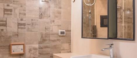 Un baño moderno con un lavamanos grande, un inodoro y una zona de ducha.
