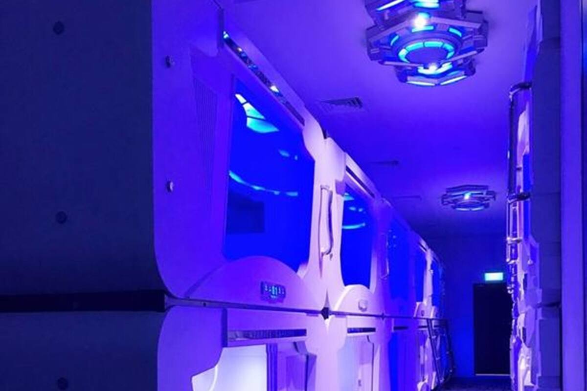 Un pasillo con salas de masoterapia, cada una con un ventanal grande y un panel de control.