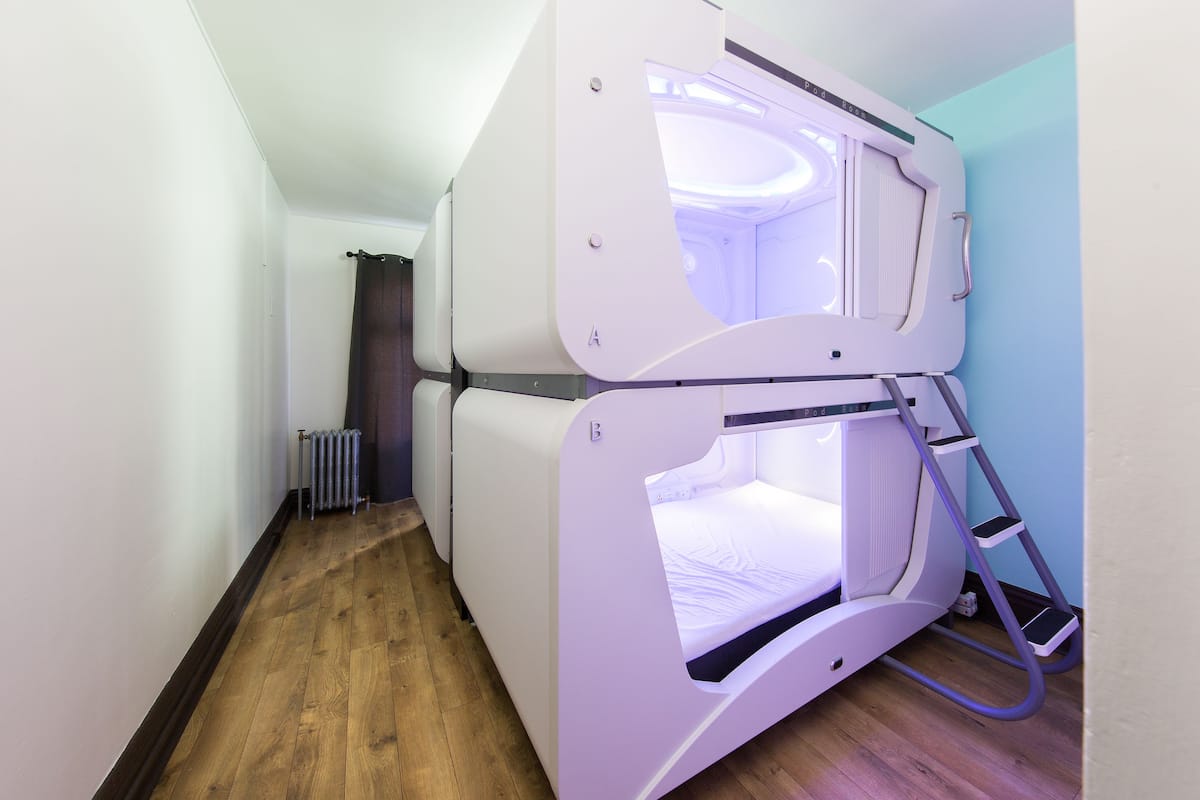 A room with a bunk bed, a radiator, and a wooden floor.