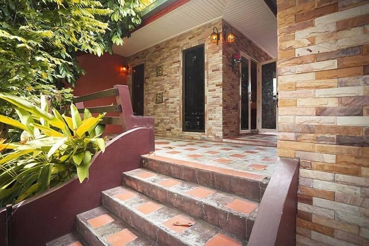 Una escalera que lleva a una habitación con pared de piedra y una puerta.