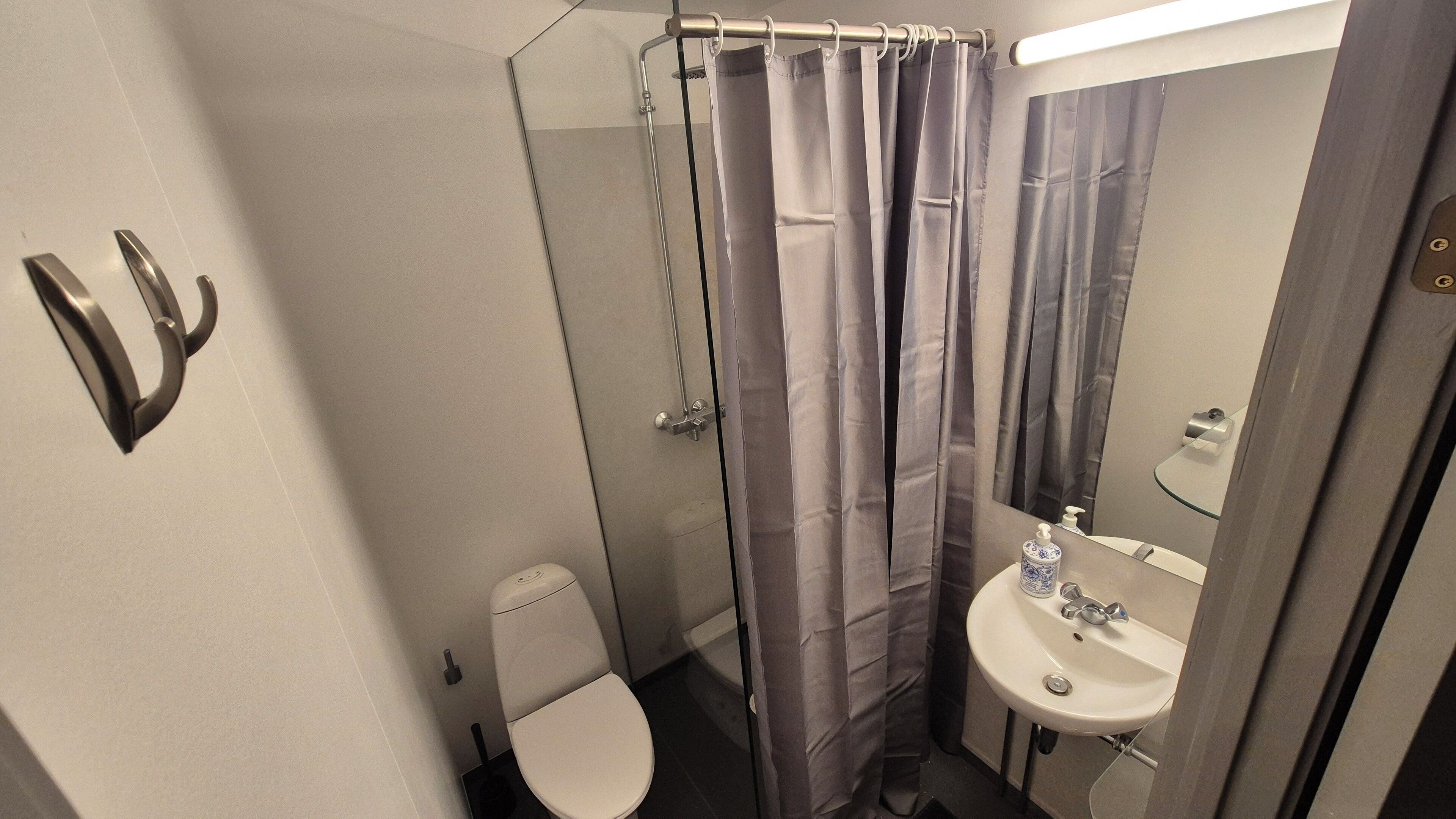 Une salle de bain avec des toilettes, un lavabo et un rideau de douche.