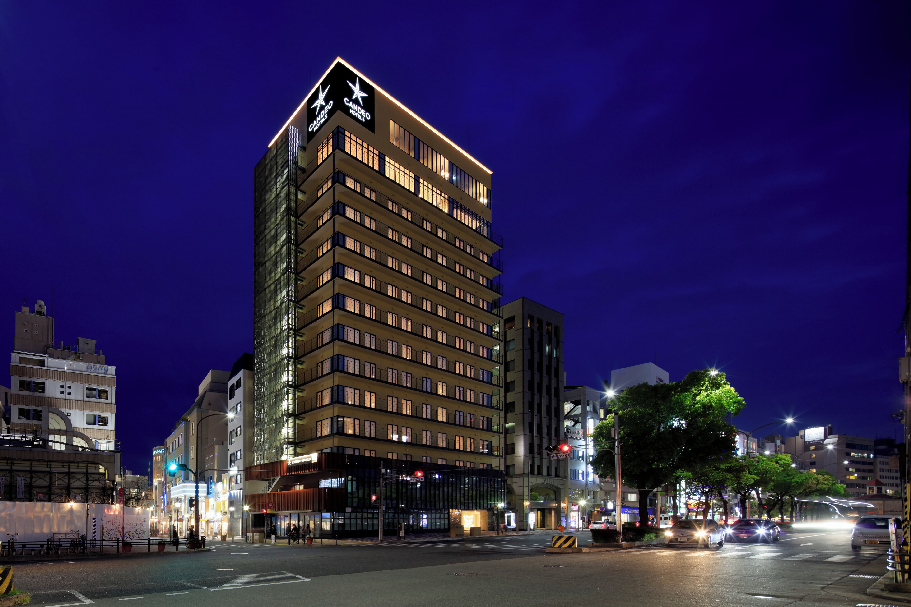 A multi-story hotel with a prominent star logo on the top, featuring a modern architectural design with numerous windows and a well-lit facade.