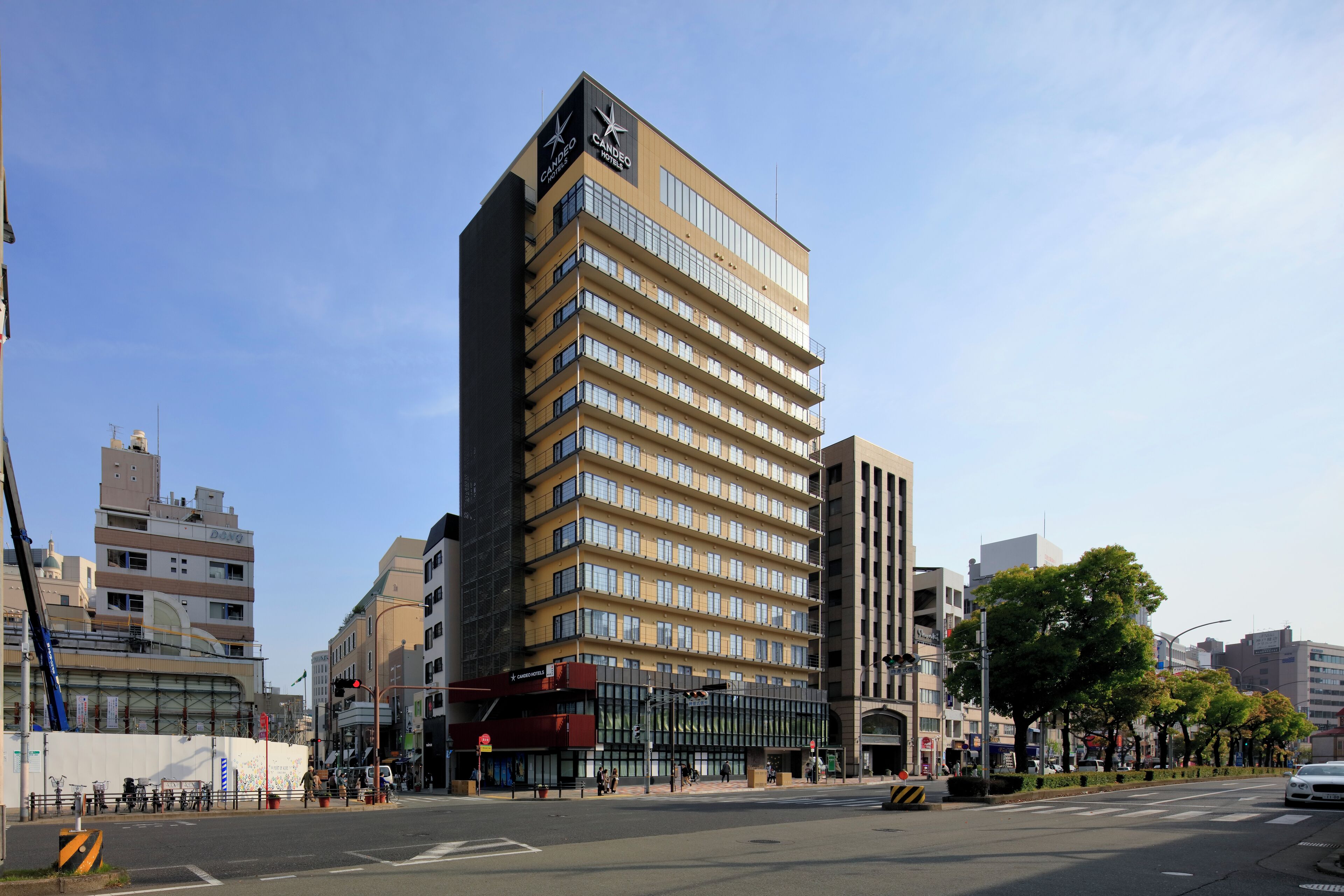 A multi-story hotel with a modern design, featuring a prominent logo on the facade.