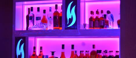 A bar with shelves of liquor bottles and glasses.