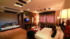 Una habitación de hotel con cama, sofá, televisor y escritorio.