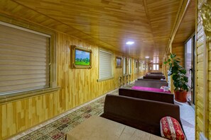 Stroll down this elegant hallway, lined with framed pictures and a potted plant, leading to cozy rooms.